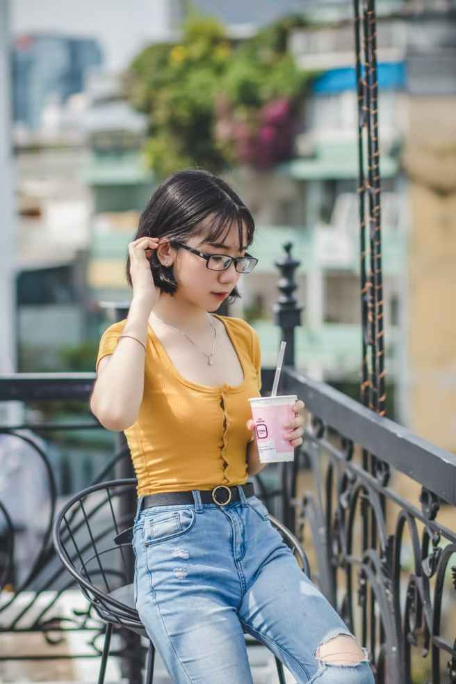 woman sitting on chair holding disposable cup
